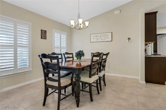 tiled dining space with vaulted ceiling and an inviting chandelier