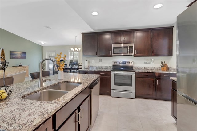 kitchen with pendant lighting, lofted ceiling, an inviting chandelier, sink, and stainless steel appliances