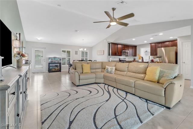 living room with ceiling fan with notable chandelier, light tile patterned flooring, and lofted ceiling