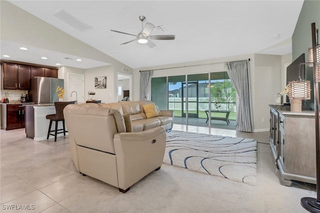 tiled living room with ceiling fan and vaulted ceiling