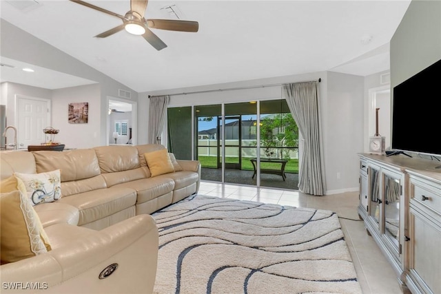 living room featuring ceiling fan, light tile patterned floors, and vaulted ceiling