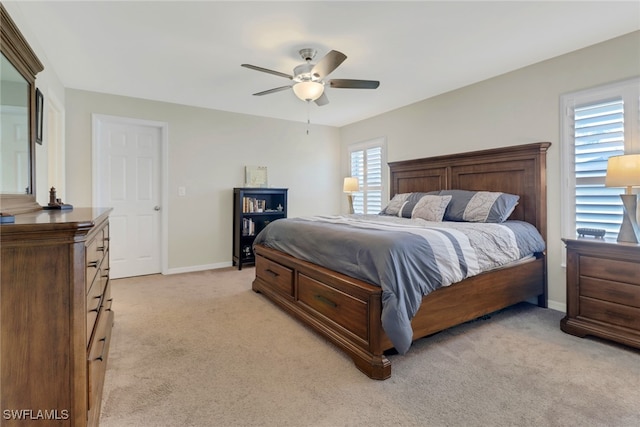 carpeted bedroom featuring ceiling fan and multiple windows