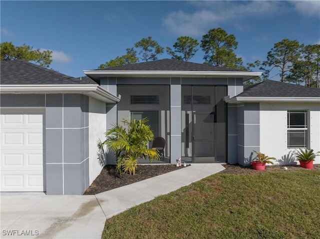 view of exterior entry with a garage and a yard