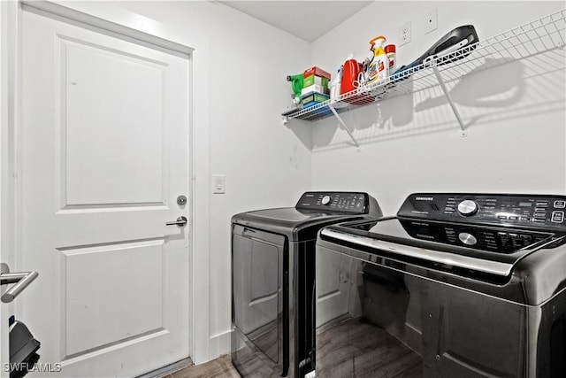 clothes washing area with hardwood / wood-style flooring and independent washer and dryer