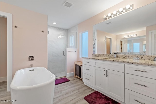 bathroom featuring vanity, independent shower and bath, and hardwood / wood-style flooring