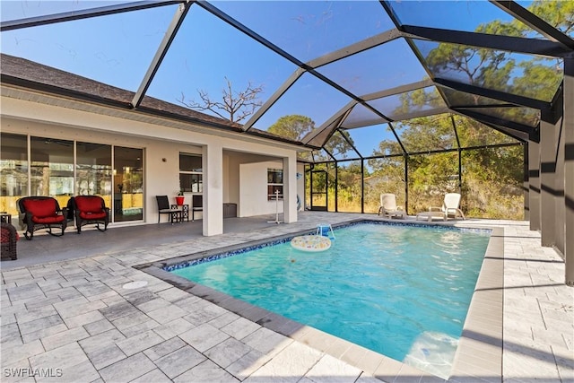 view of pool featuring glass enclosure and a patio