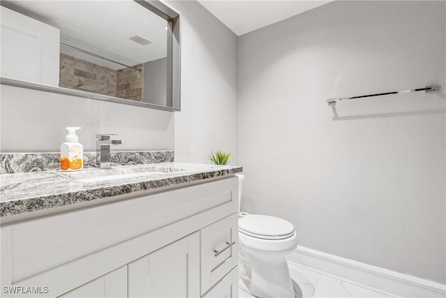 bathroom with vanity, toilet, and walk in shower