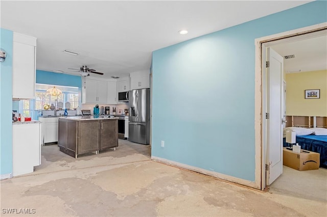 kitchen featuring white cabinets, stainless steel appliances, a kitchen island, and ceiling fan