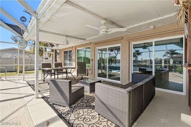 view of patio / terrace featuring an outdoor hangout area, glass enclosure, and ceiling fan