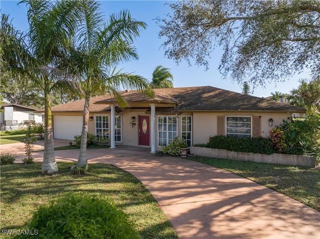 ranch-style house featuring a garage and a front lawn