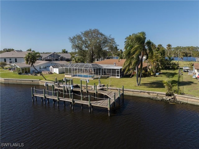 dock area featuring glass enclosure, a water view, and a yard