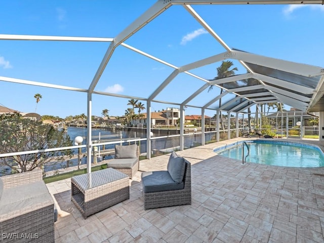 view of swimming pool with a patio, a water view, and glass enclosure