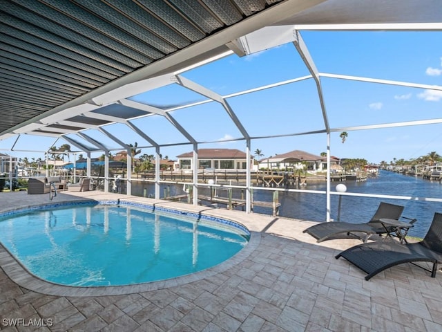 view of swimming pool with glass enclosure, a water view, and a patio