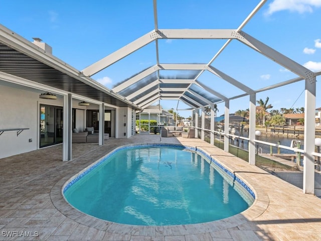 view of swimming pool with a lanai, a patio area, an outdoor hangout area, and a water view