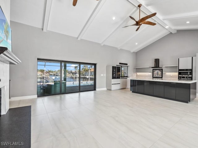 unfurnished living room featuring ceiling fan, beamed ceiling, and high vaulted ceiling