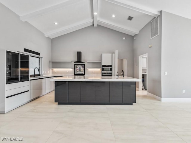 kitchen featuring a large island, sink, white fridge with ice dispenser, beamed ceiling, and ventilation hood