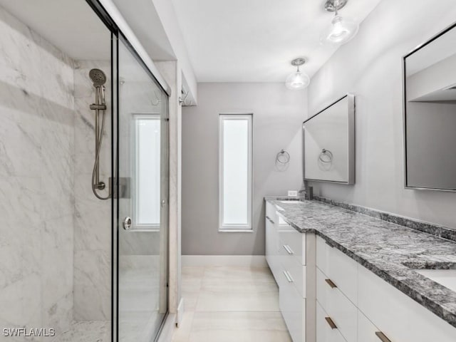 bathroom with tile patterned floors, vanity, and a shower with door