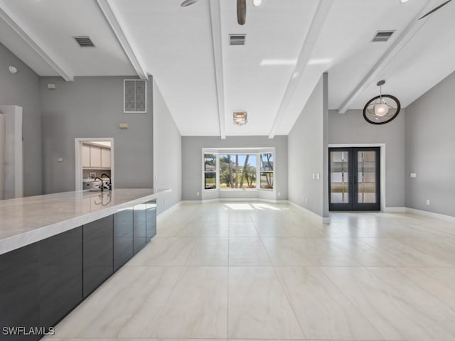 unfurnished living room featuring french doors, sink, beam ceiling, light tile patterned floors, and high vaulted ceiling