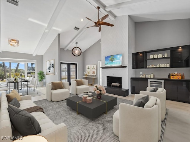 living room with high vaulted ceiling, wine cooler, ceiling fan, beam ceiling, and a large fireplace