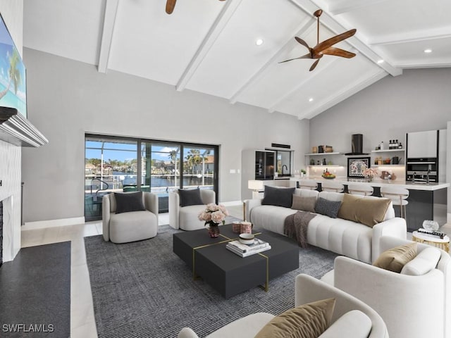 living room with tile patterned floors, ceiling fan, a premium fireplace, and high vaulted ceiling