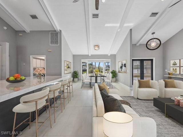 living room with beam ceiling, high vaulted ceiling, and french doors