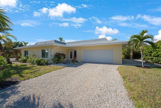 single story home with a garage and a front lawn