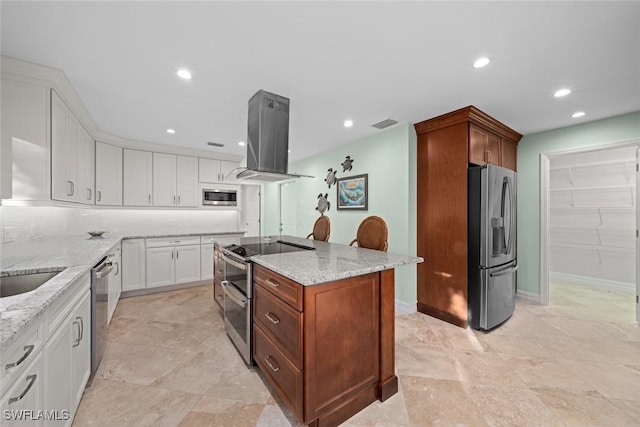 kitchen with light stone counters, island range hood, white cabinetry, appliances with stainless steel finishes, and a center island