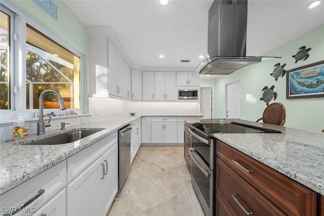 kitchen with sink, white cabinetry, tasteful backsplash, island exhaust hood, and stainless steel appliances