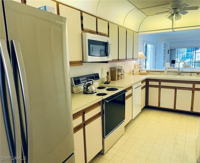 kitchen with white appliances, ceiling fan, sink, light tile patterned floors, and white cabinetry