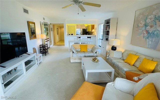 living room with ceiling fan and light colored carpet