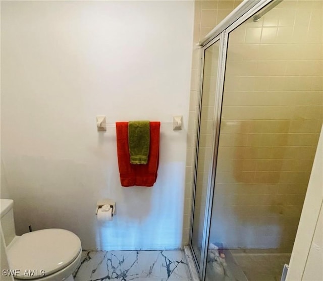 bathroom with toilet and a shower with shower door