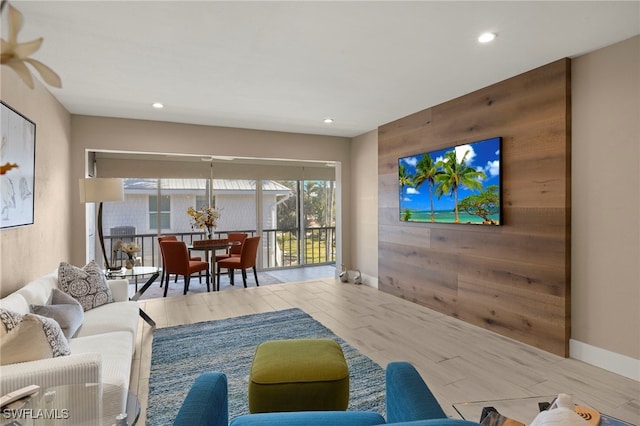 living room with wooden walls and light hardwood / wood-style flooring