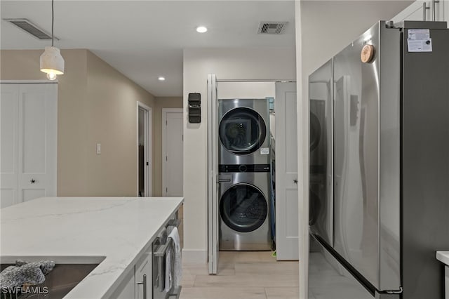 washroom featuring stacked washing maching and dryer