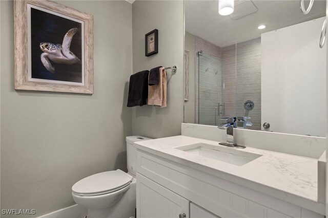 bathroom featuring toilet, walk in shower, and vanity