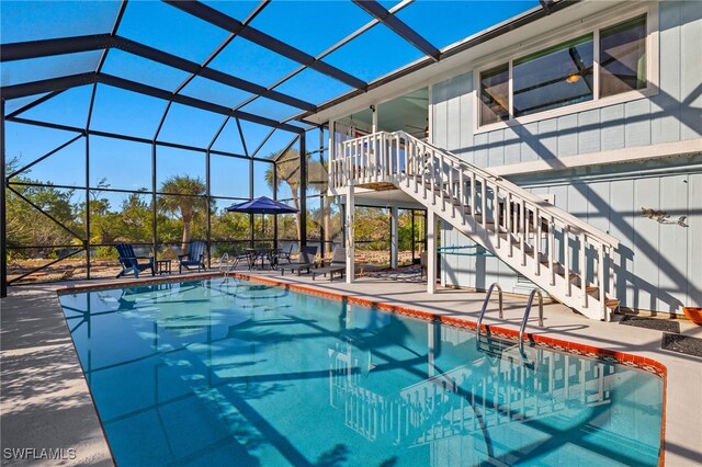 view of swimming pool with a lanai and a patio area