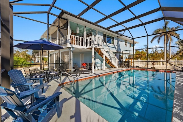 view of swimming pool featuring glass enclosure, ceiling fan, and a patio area