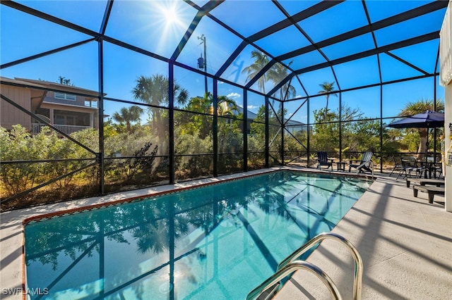 view of swimming pool featuring a patio area and glass enclosure