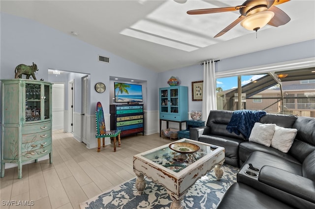 living room with ceiling fan, lofted ceiling, and light wood-type flooring