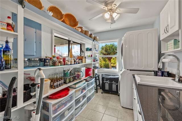 interior space with stacked washer and dryer, light tile patterned floors, sink, and ceiling fan