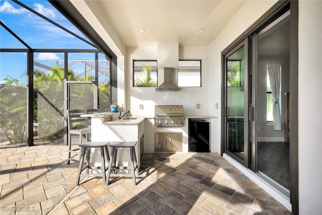 view of patio / terrace with a lanai, area for grilling, sink, and grilling area