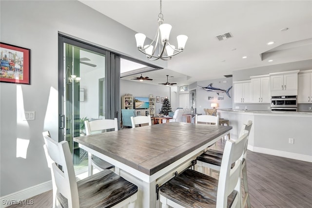 dining area with dark hardwood / wood-style flooring and ceiling fan with notable chandelier