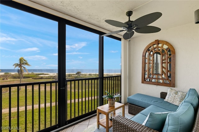 sunroom featuring ceiling fan, plenty of natural light, and a water view