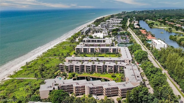 birds eye view of property with a water view and a beach view