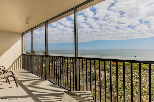 balcony with a water view and a beach view