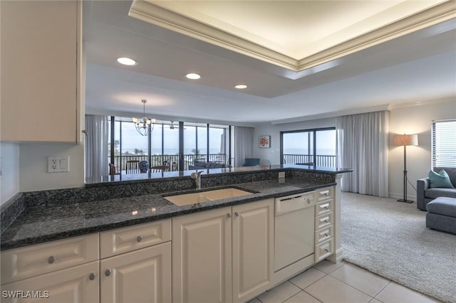 kitchen with dishwasher, sink, dark stone countertops, light colored carpet, and white cabinetry