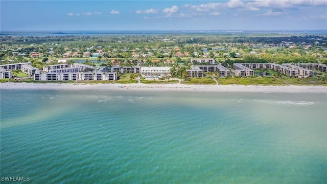 birds eye view of property with a water view and a beach view