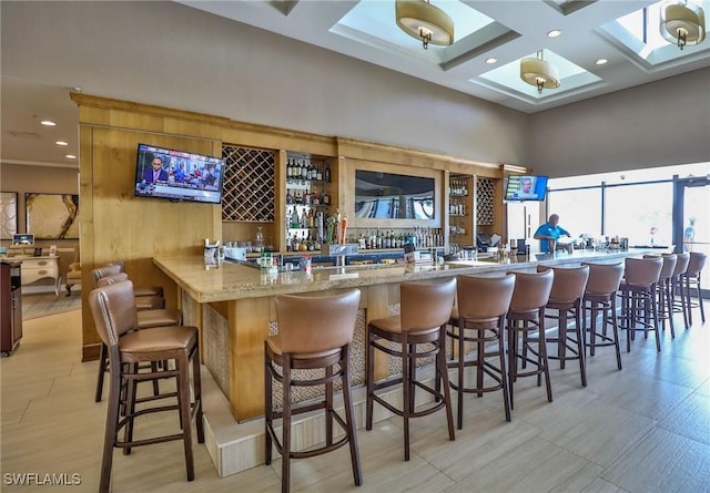 bar with beam ceiling, light stone counters, and coffered ceiling