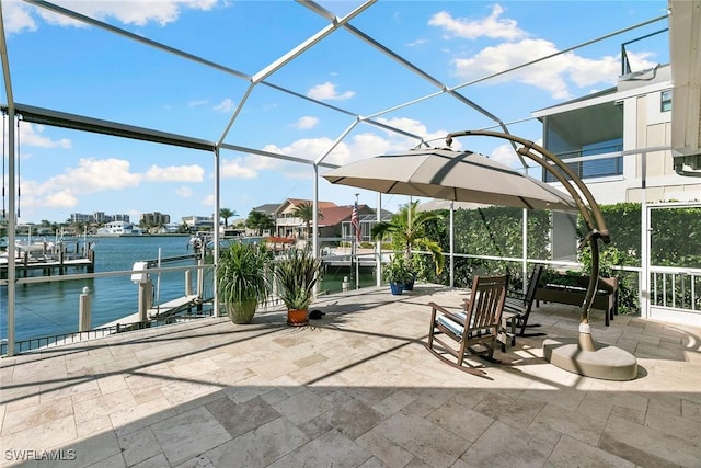 view of patio featuring glass enclosure, a water view, and a boat dock