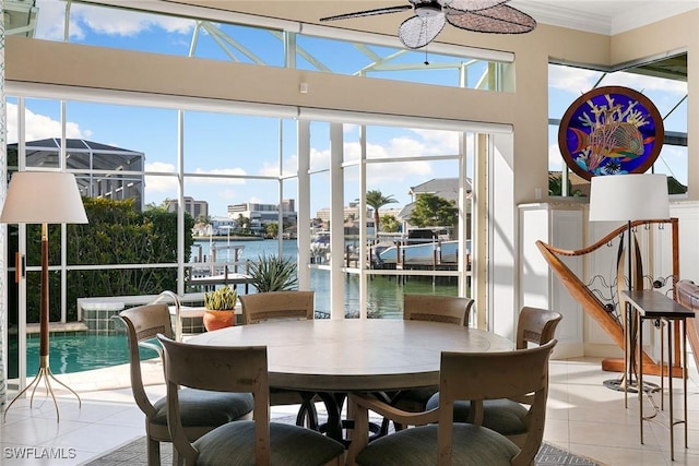 dining room featuring light tile patterned floors, a water view, and crown molding