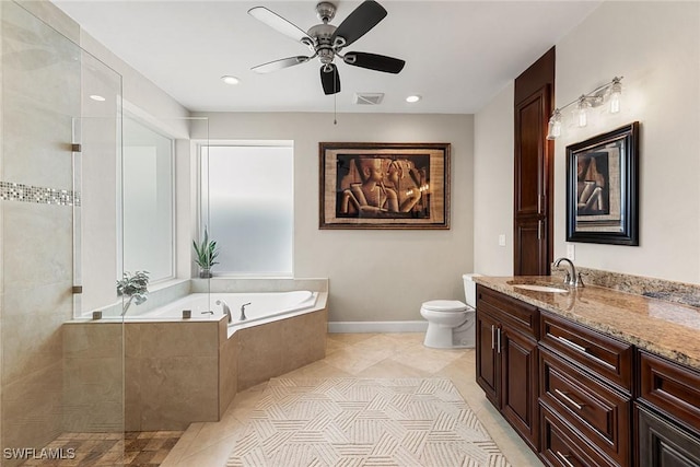 bathroom featuring vanity, tile patterned floors, a relaxing tiled tub, ceiling fan, and toilet